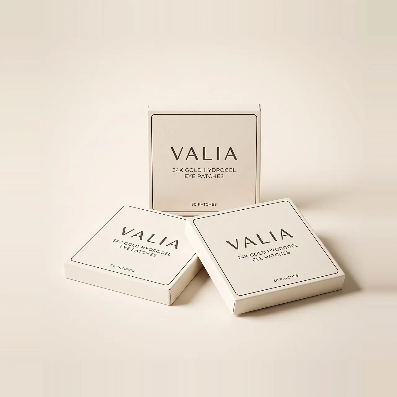 Three identical VALIA boxes on a cream surface, one standing behind two laid flat.